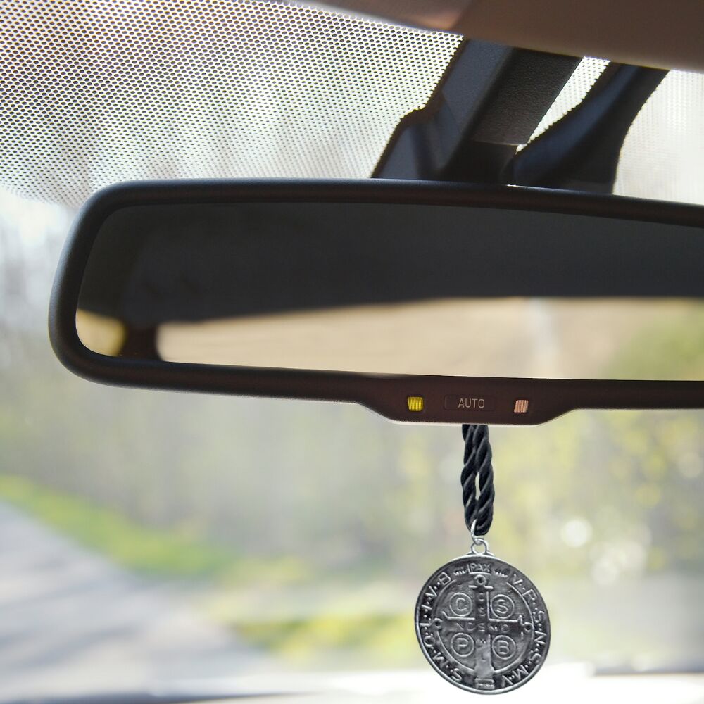 St. Benedict door hanger hanging from rearview mirror in a car