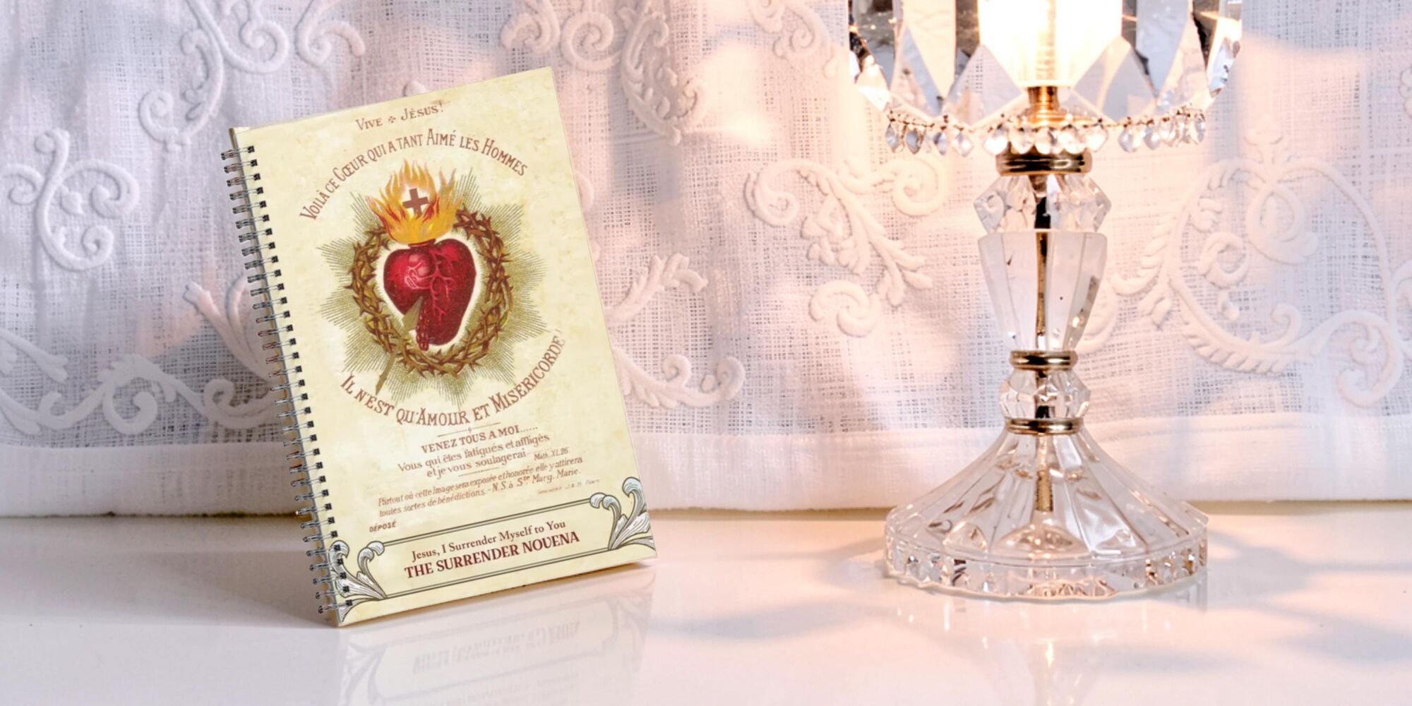 Sacred Heart writing journal next to crystal lamp